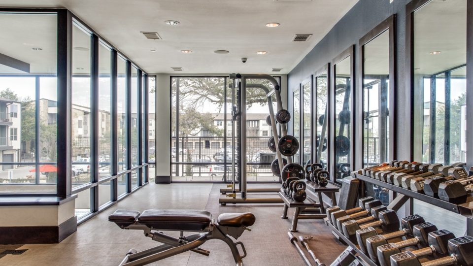 a gym room with a large window and a large mirror at The Live Oak at  Branch