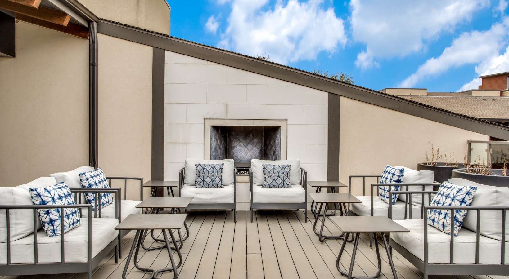 patio furniture on a rooftop with a fireplace at The Live Oak at  Branch