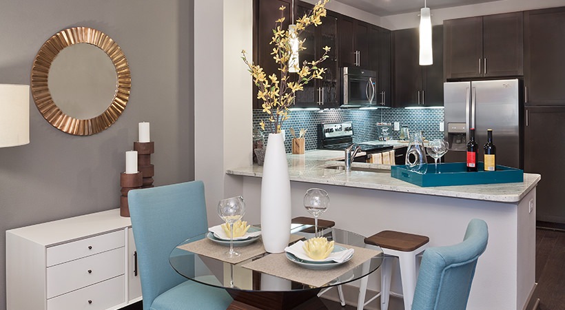 a modern kitchen and dining area with blue chairs at The Live Oak at  Branch