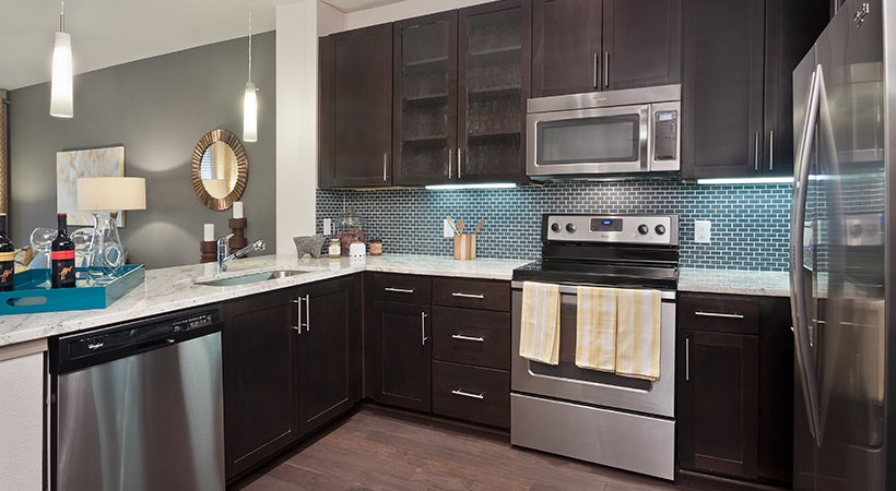 a kitchen with stainless steel appliances and wood cabinets at The Live Oak at  Branch