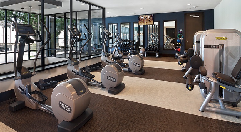 a gym room with exercise equipment and mirrors at The Live Oak at  Branch